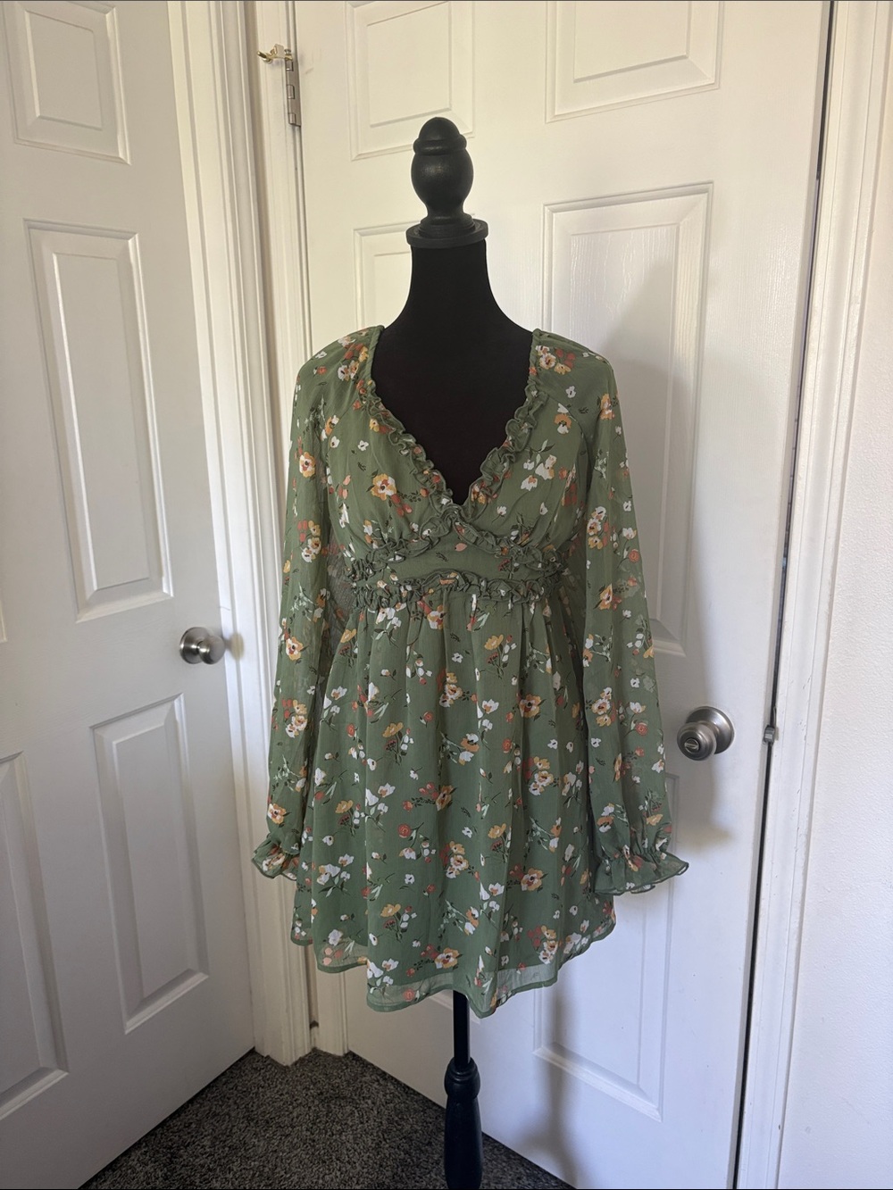 Inspired Hearts green floral babydoll dress with long sleeves and a V-neckline.